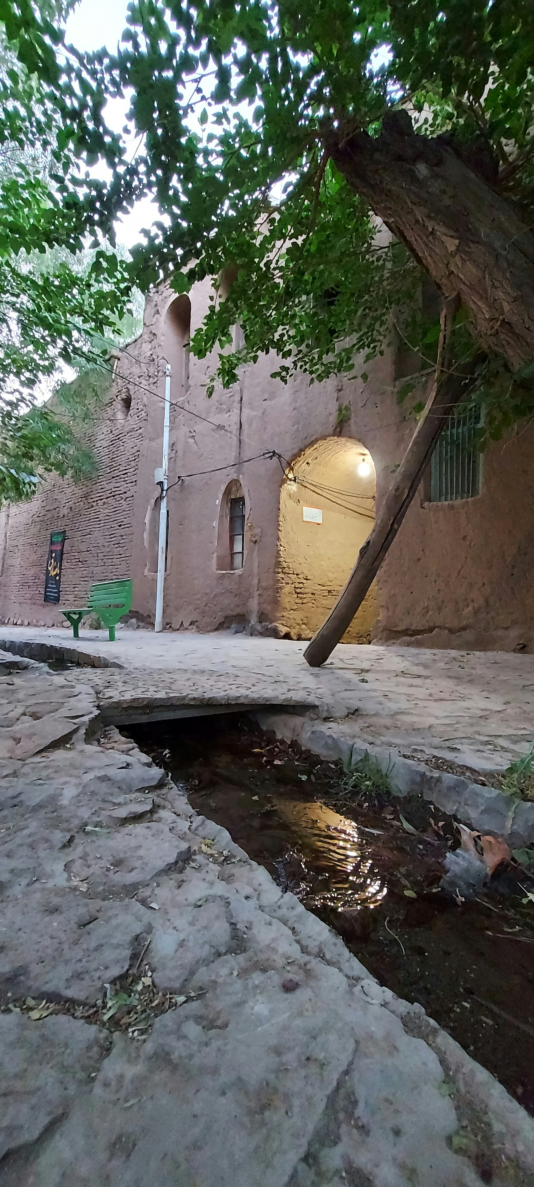 A brick building with a puddle in front of it photo – Free Flagstone ...