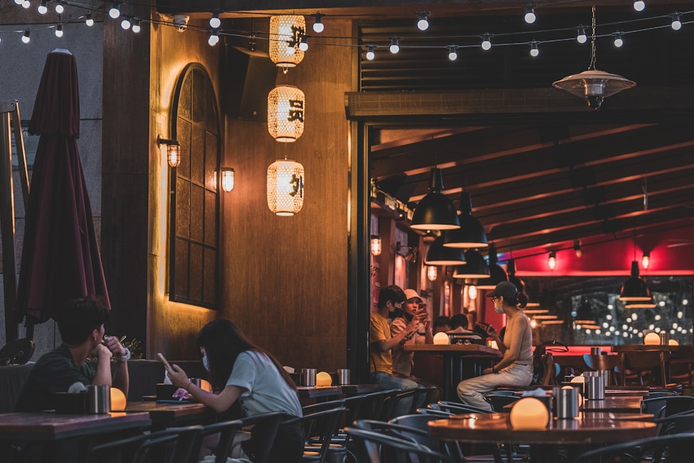 people sitting at tables in a restaurant