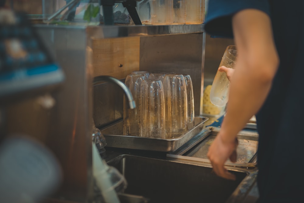 a person pouring liquid into a glass