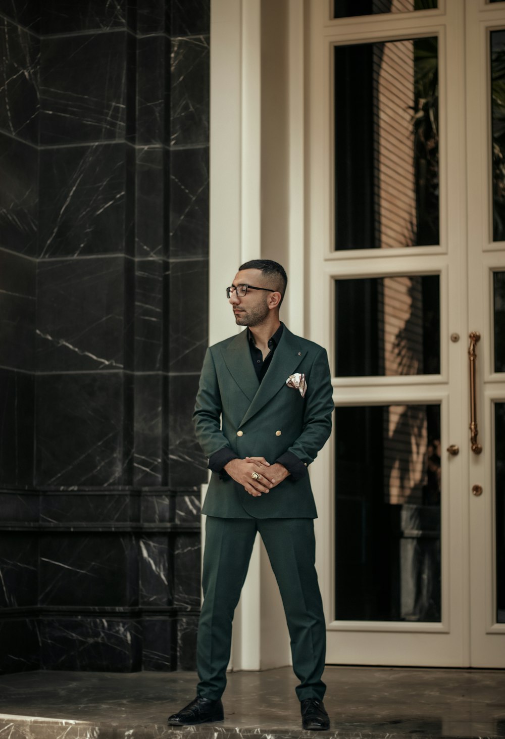 a man in a suit standing in front of a door