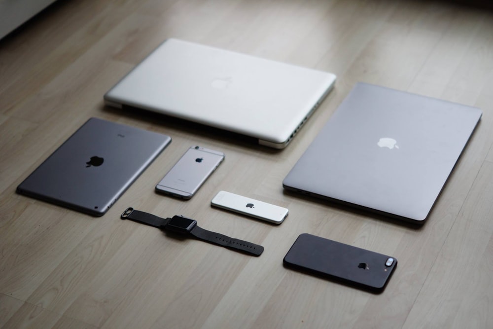 a group of cell phones and laptops on a table