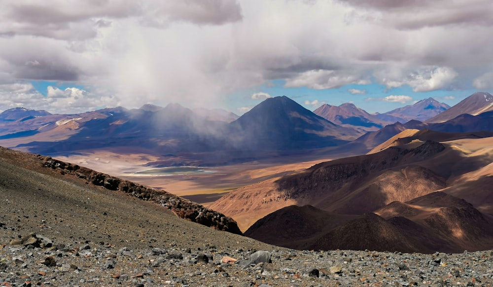 a rocky landscape with mountains in the background