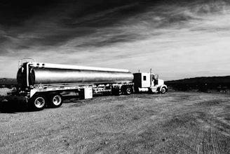 A large sweet water tanker truck parked by a desert road under a clear blue sky in Abu Dhabi.