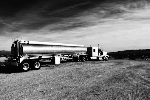 A large sweet water tanker truck parked by a desert road under a clear blue sky in Abu Dhabi.