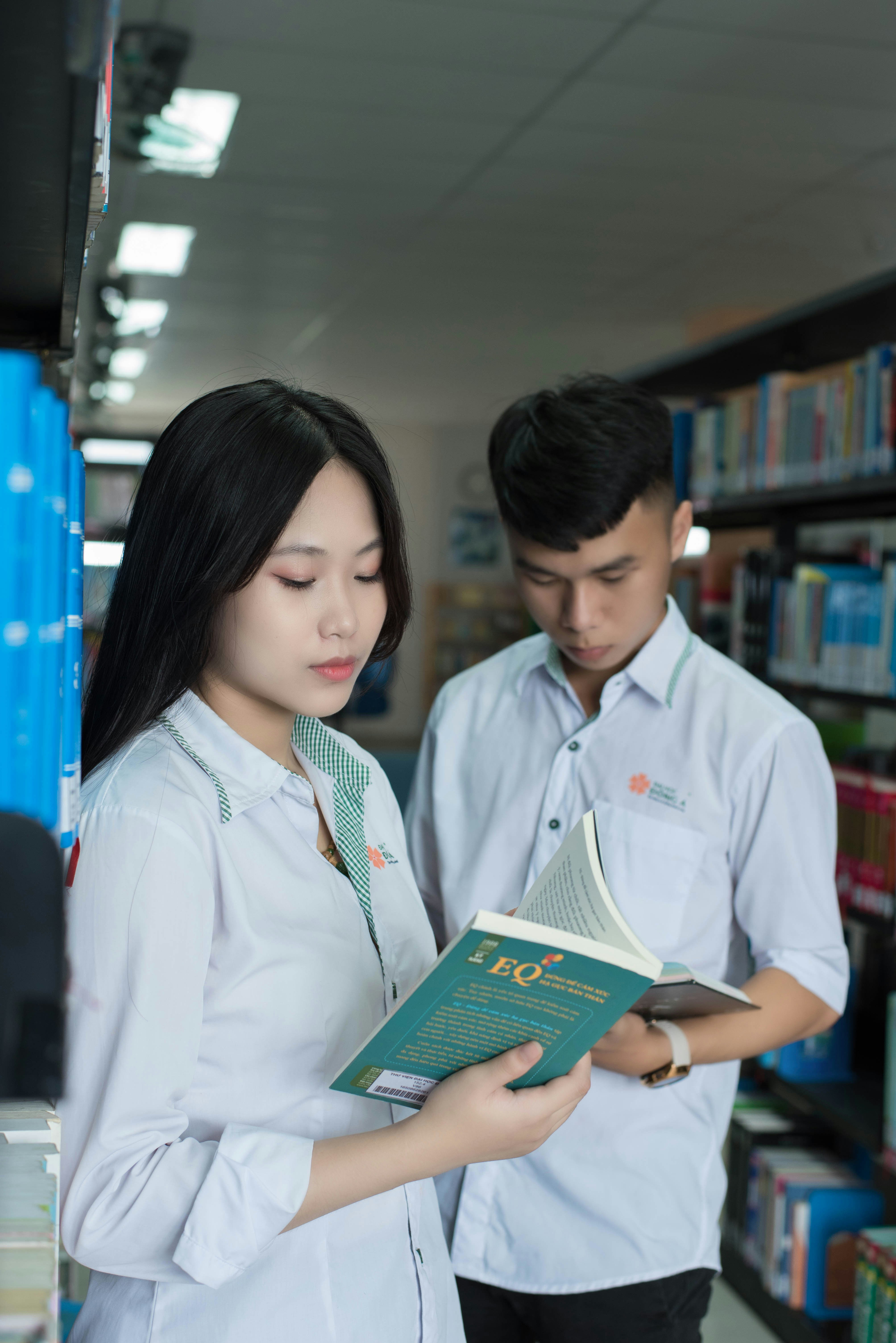 a man and a woman looking at a book