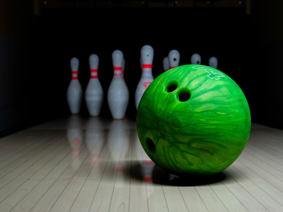 close-up of bowling ball in front of pins
