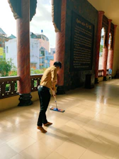 A friendly cleaning professional carefully wiping a hospital corridor in Queretaro.
