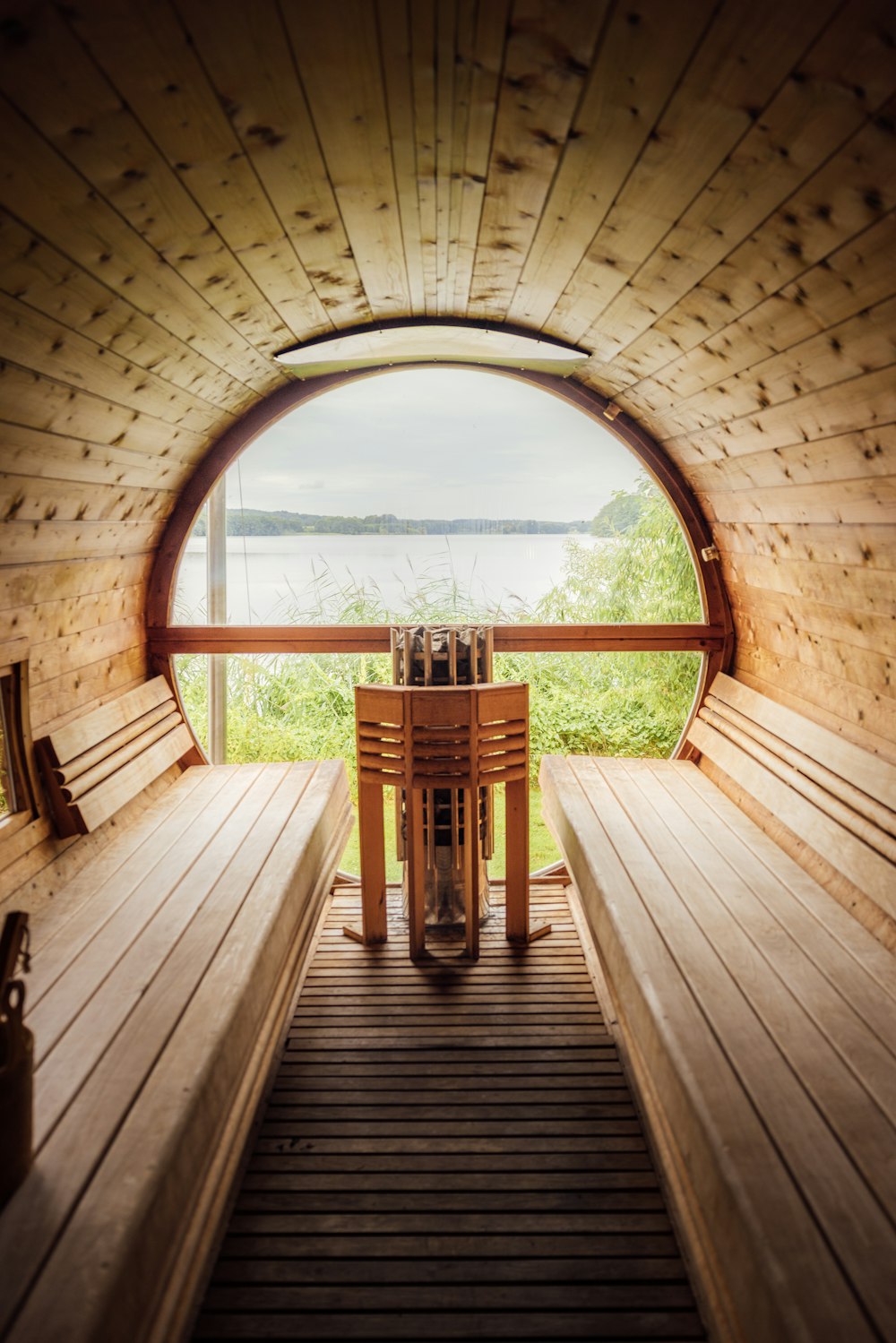 a wooden walkway with a wood railing and a wood railing with a view of a lake and trees