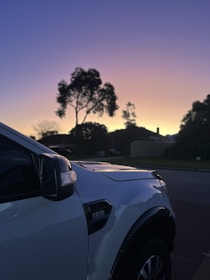 Close-up of a truck wheel on a paved road during sunset.