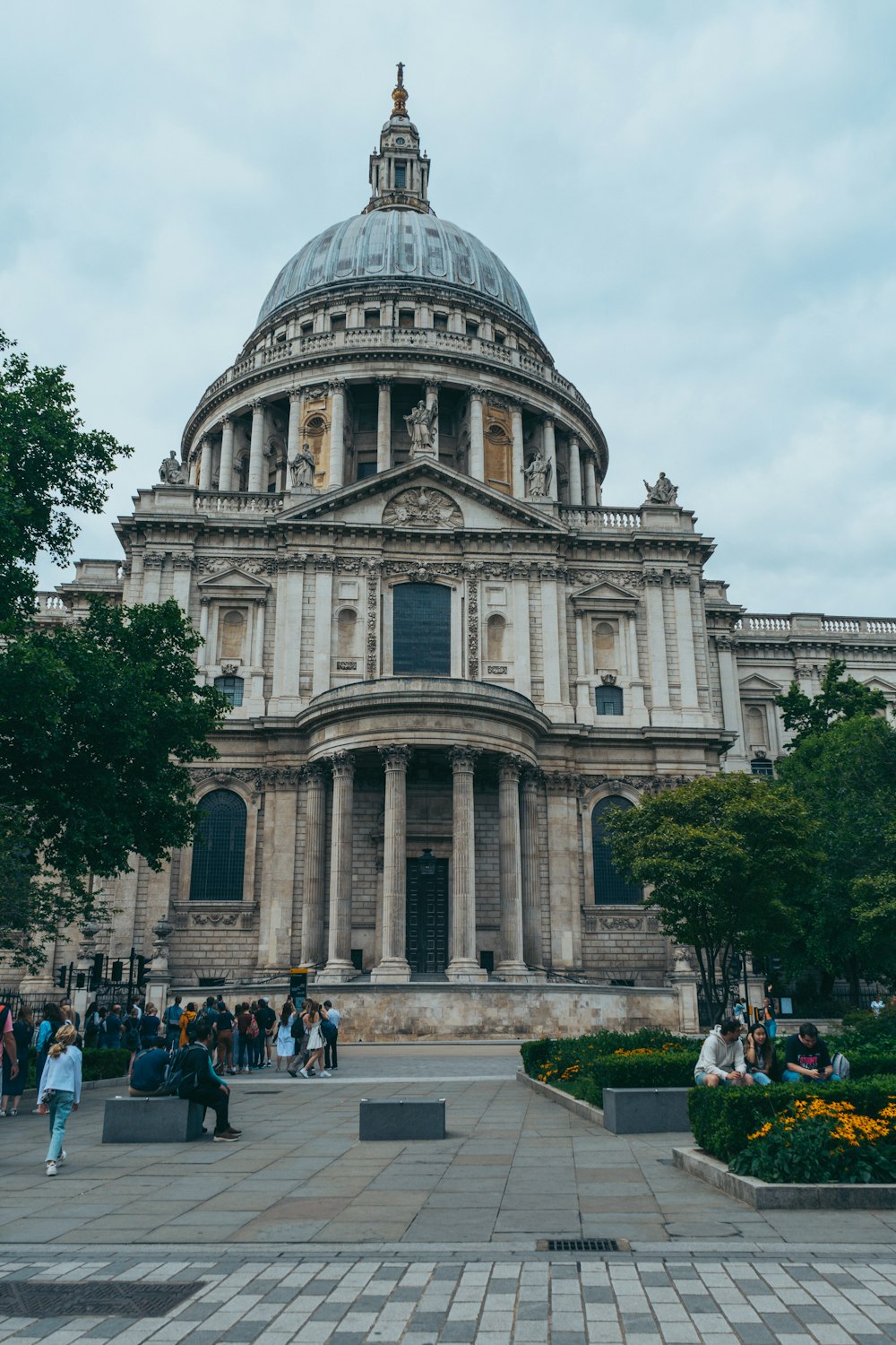 a large building with a dome and many people walking around