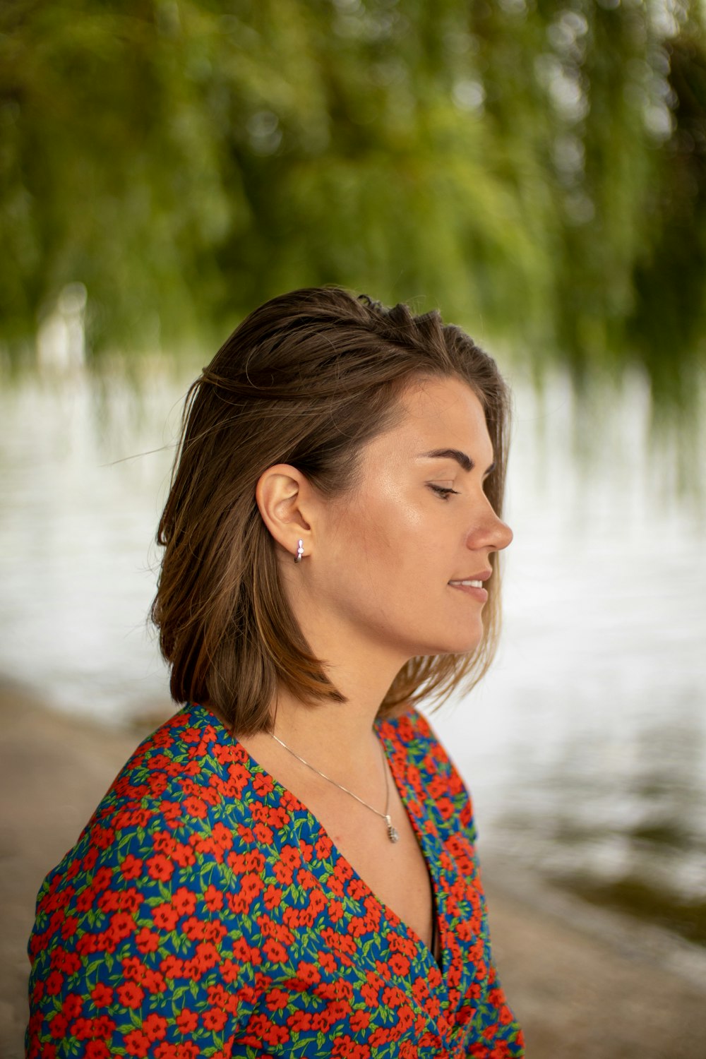 a woman smiling with a body of water in the background