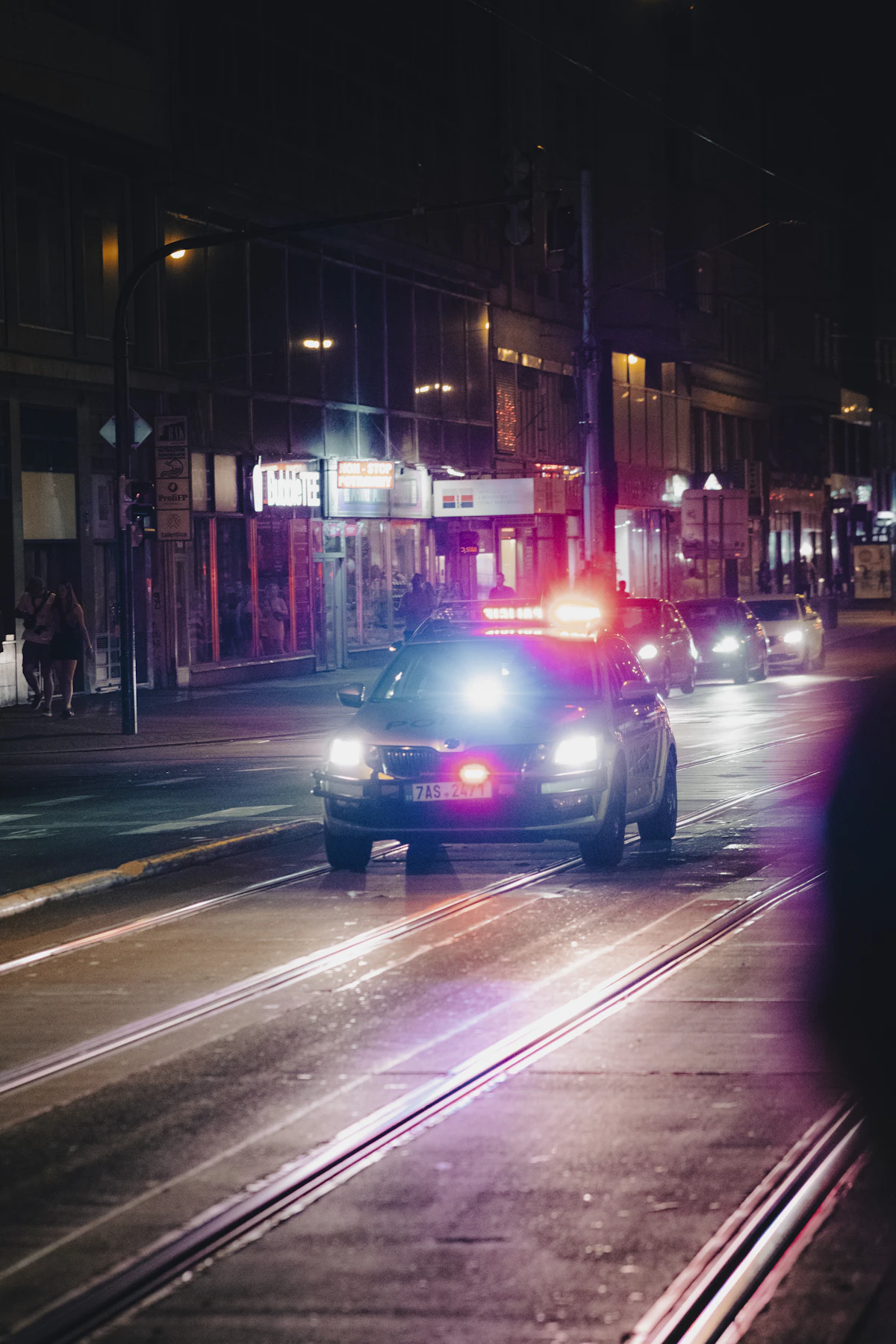 Mobil polisi di jalan kota pada malam hari.
