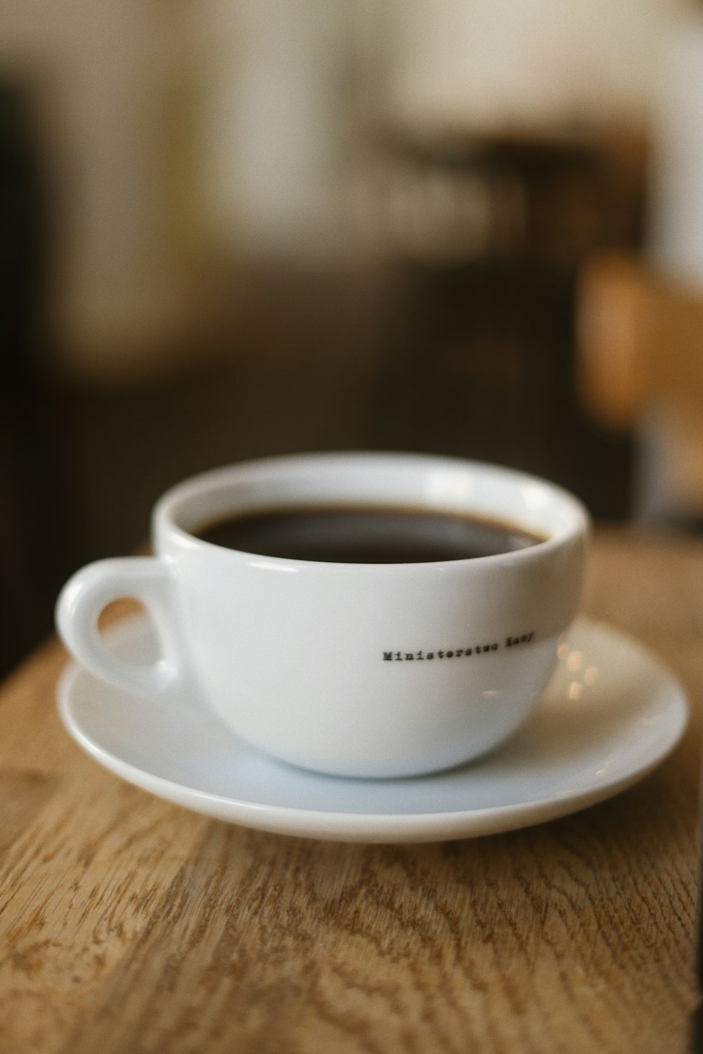 a white cup with a black logo on it