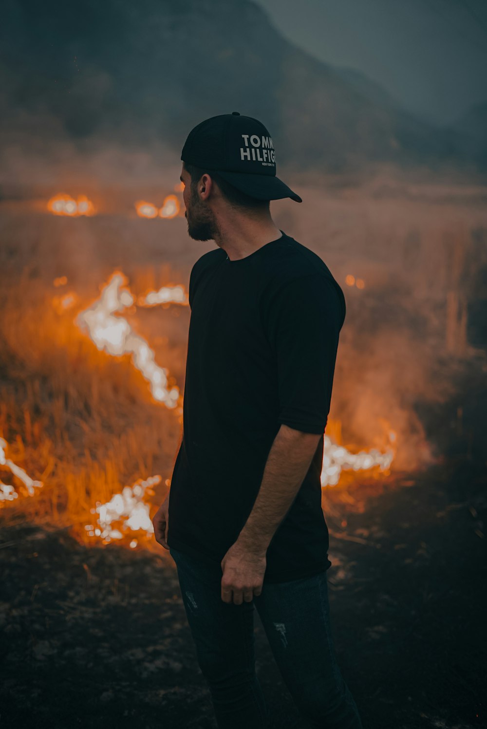 a man standing in front of a fire