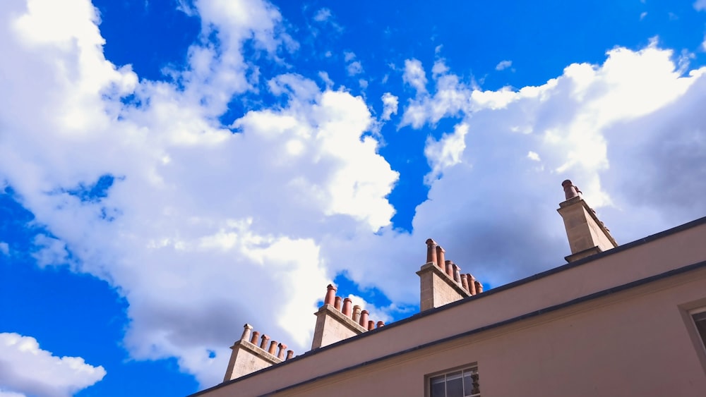 a building with a blue sky and clouds above