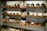 A collection of vintage cameras and magazines displayed on wooden shelves. The shelves are filled with various models of old cameras, alongside issues of LIFE magazine. Some small retro gadgets and books are also placed on the shelves.