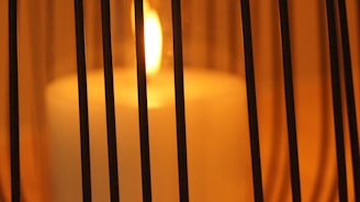 Close-up of a flickering candle flame casting warm shadows in a cozy room
