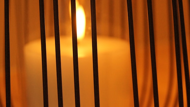 Close-up of a flickering candle flame casting warm shadows in a cozy room