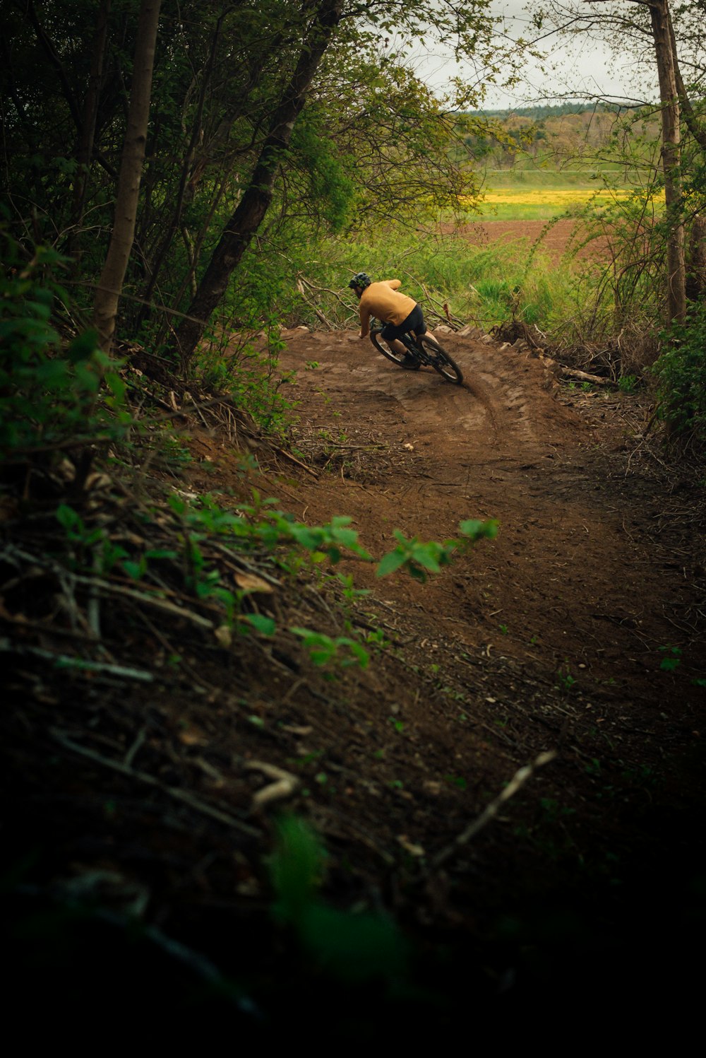 숲속의 흙길에서 자전거를 타는 사람