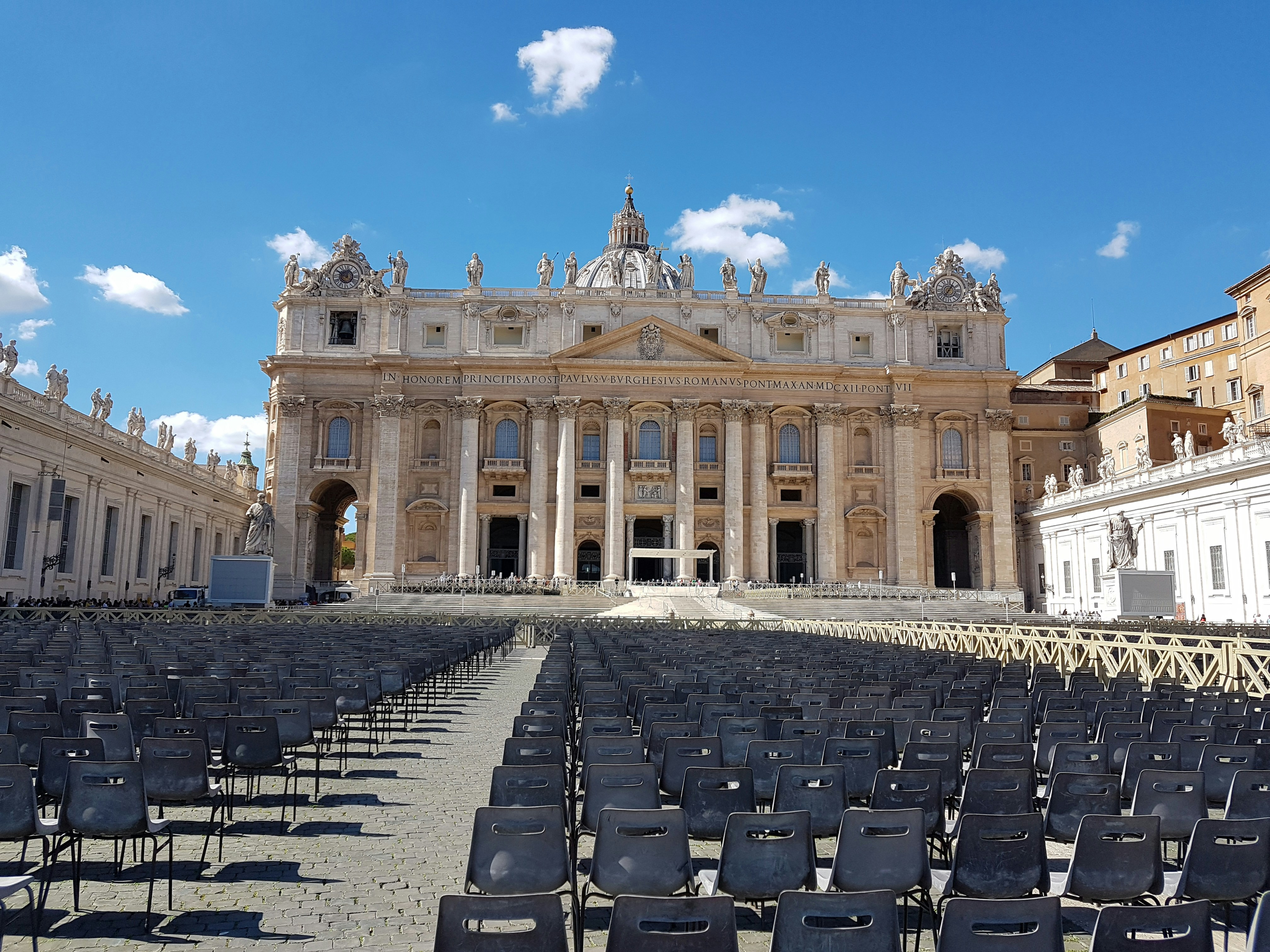 ein großes Gebäude mit vielen Stühlen davor