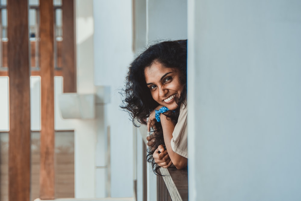 a person smiling and holding a pen