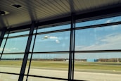An aerial view of a busy airport with planes taking off and landing under a clear blue sky.