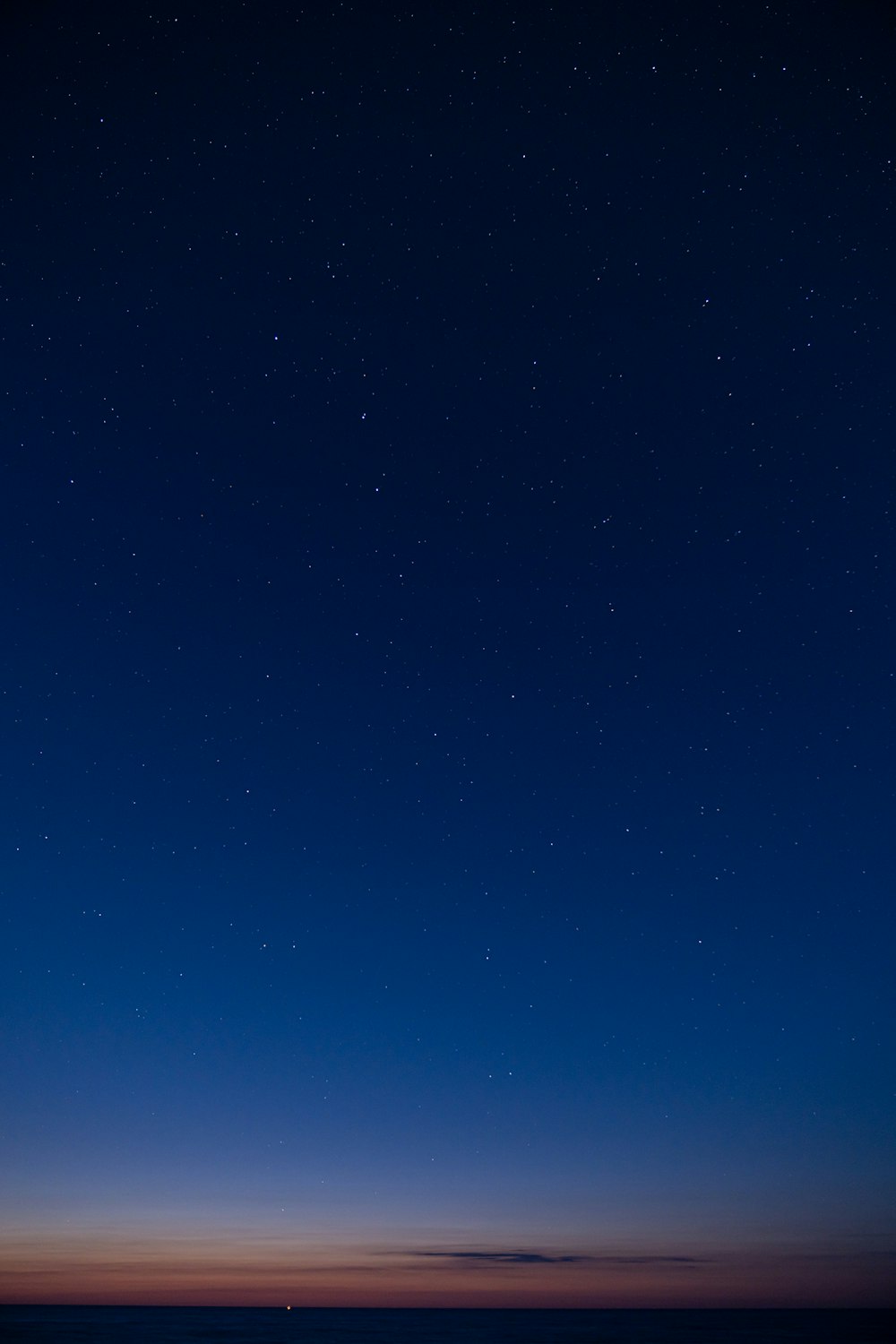 a starry night sky over a flat plain