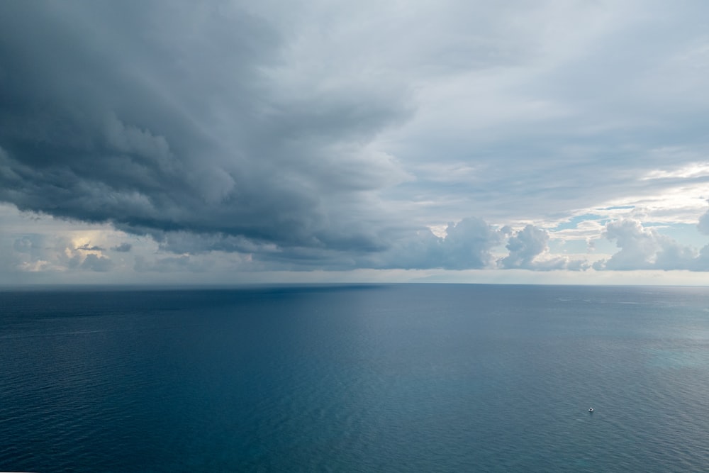 a body of water with clouds above it