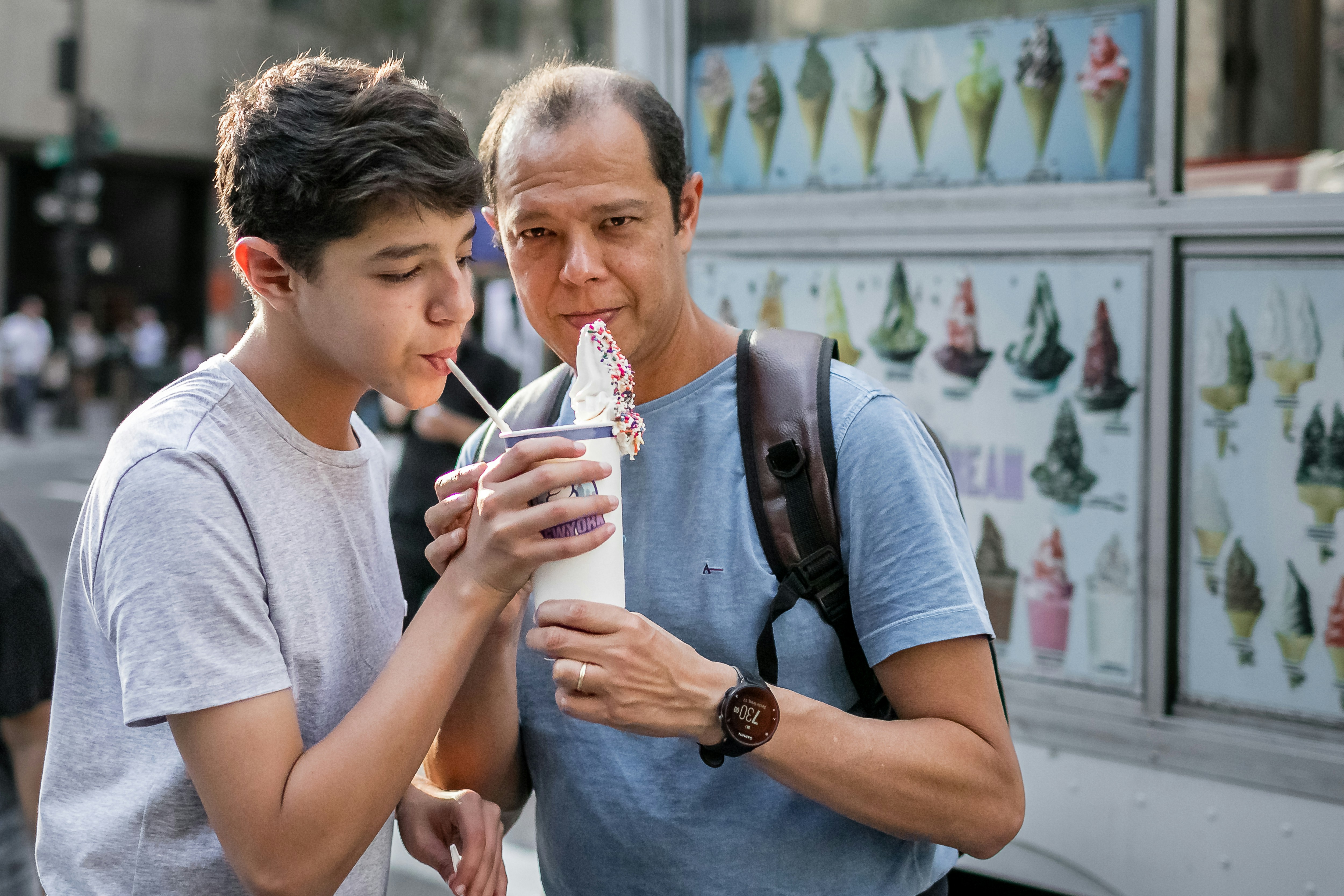 a person holding a drink and another man holding a cup