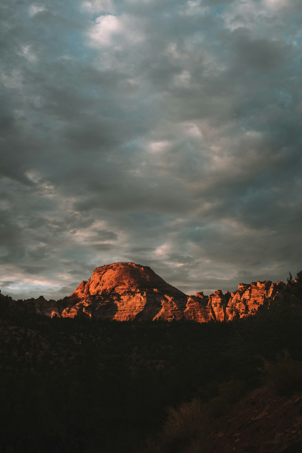 a rocky mountain with clouds above