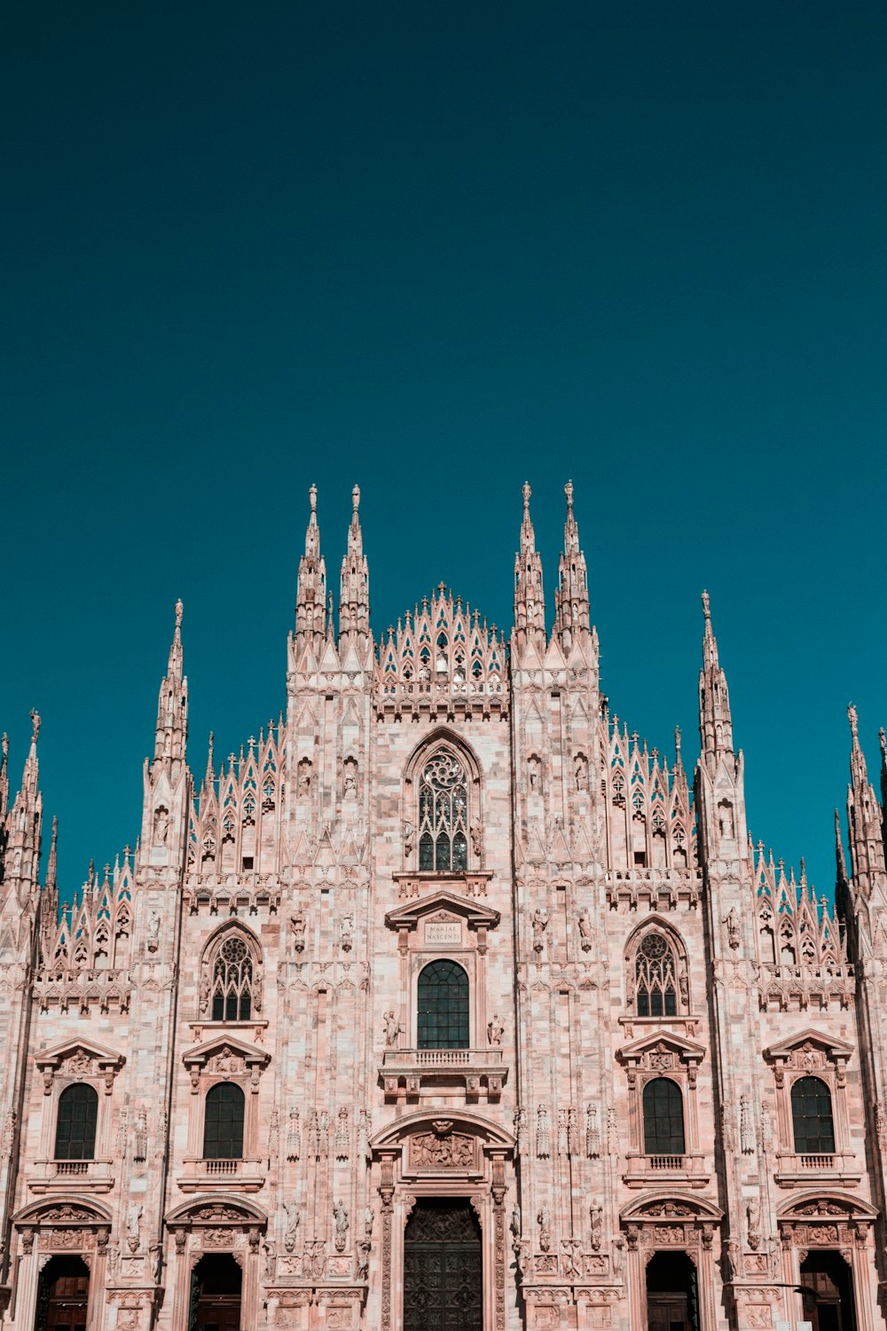 un grand bâtiment en pierre avec la cathédrale de Milan en arrière-plan