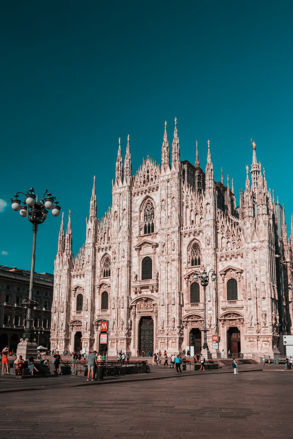 un gran edificio de piedra con la Catedral de Milán al fondo