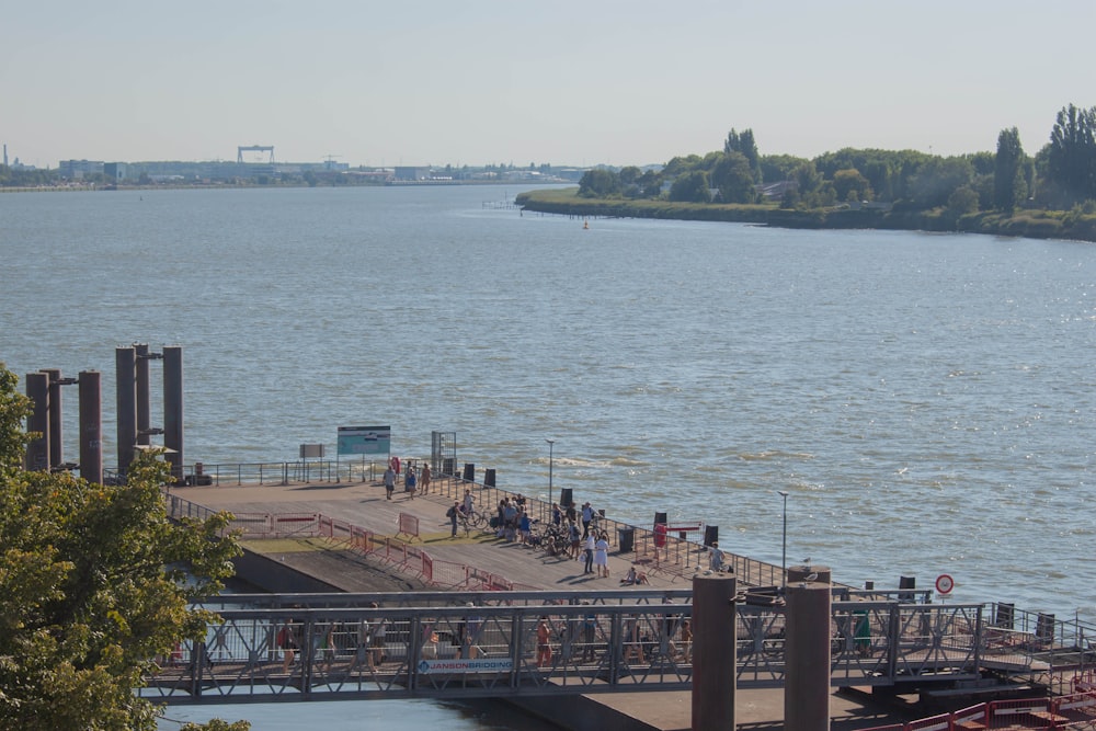 a group of people walking on a dock over a body of water