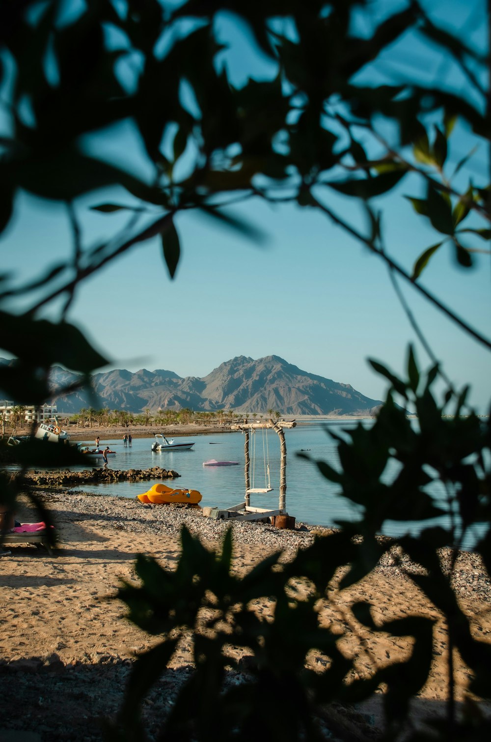 a beach with boats and a mountain in the background