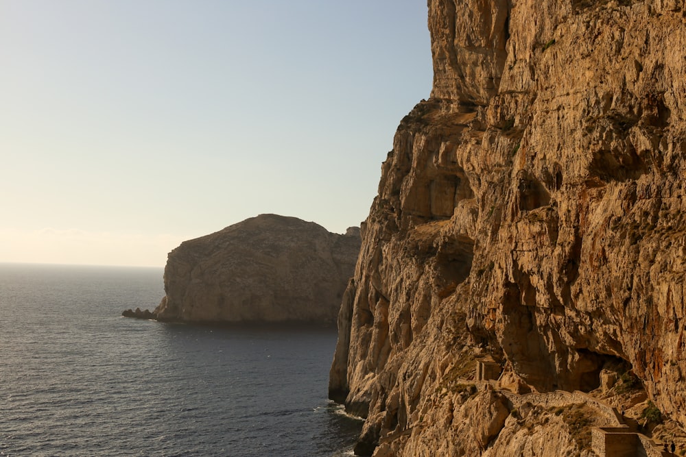 a cliff side with a body of water below