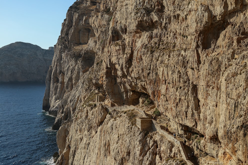 a cliff side with a body of water below