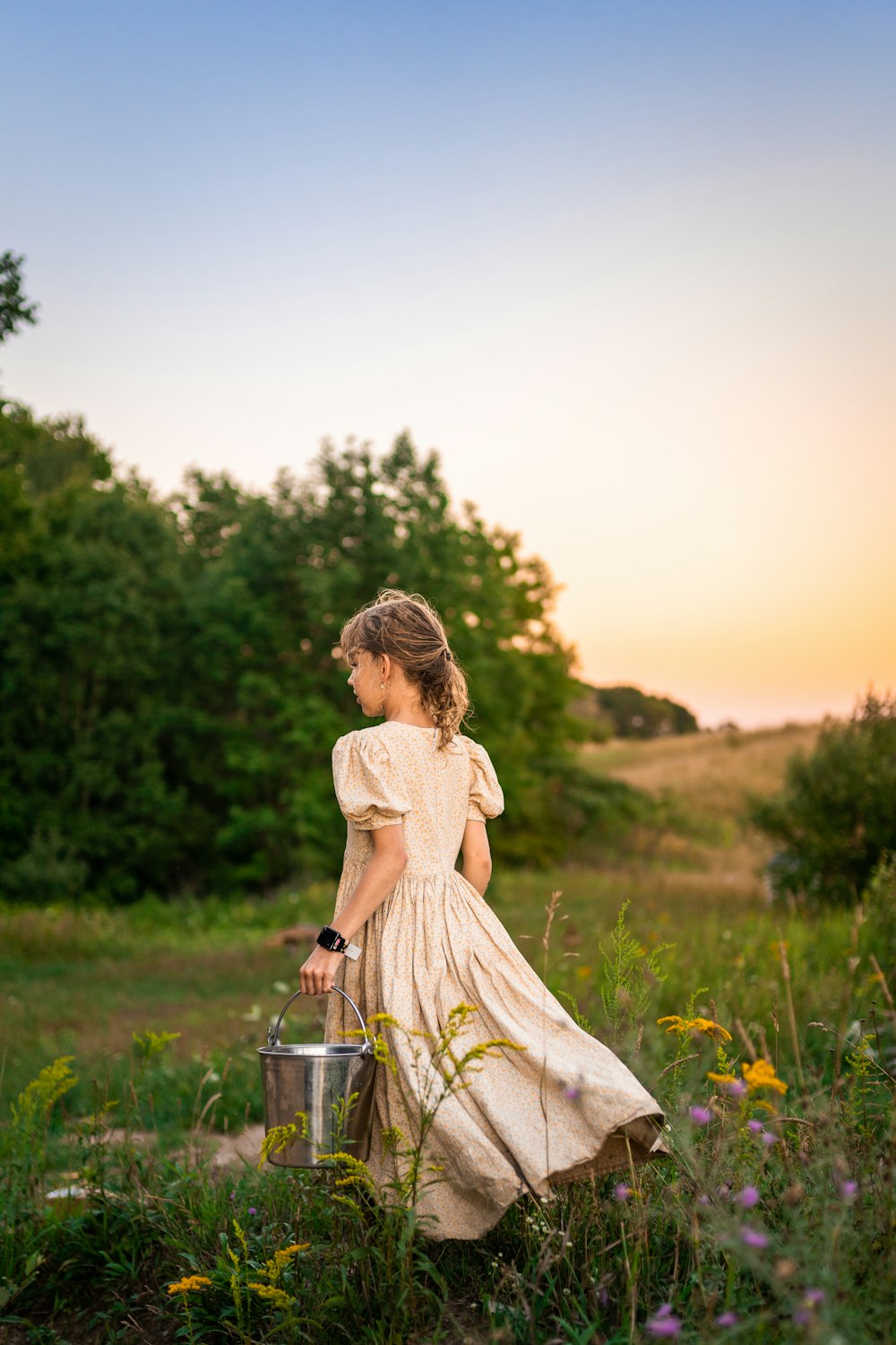 a man holding a bucket in a field of flowers