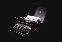 a black and white photo of a typewriter with a black background