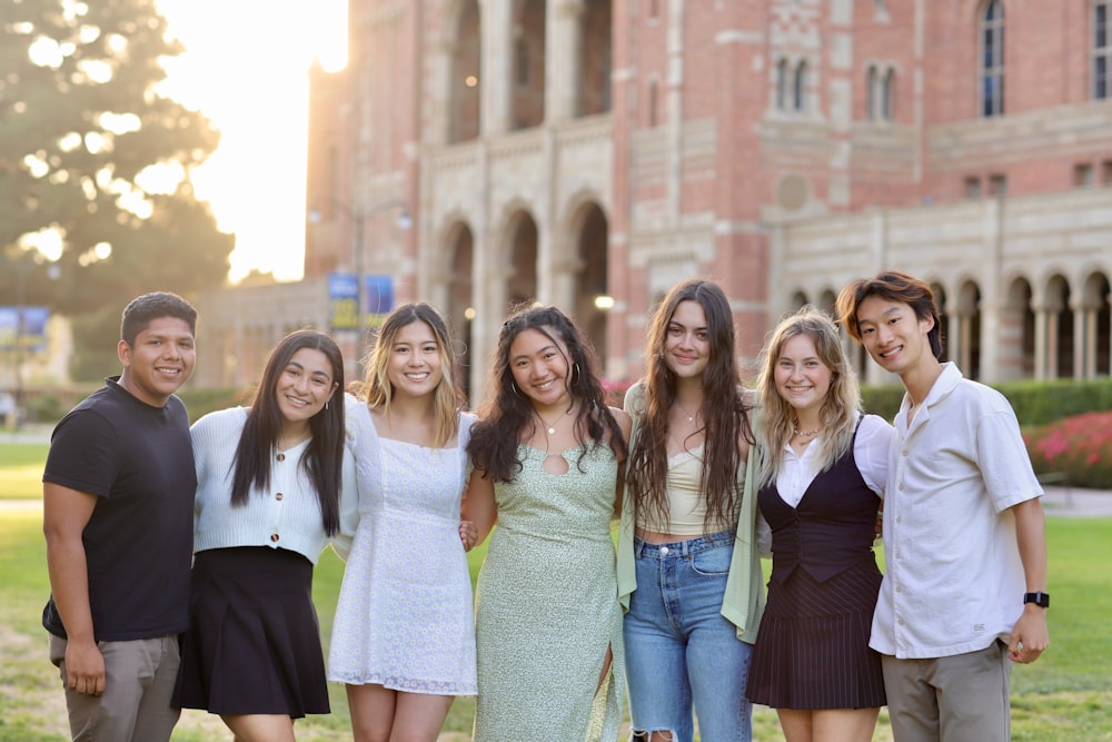 a group of people posing for a photo in front of a building