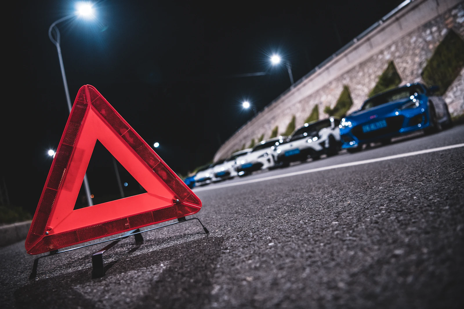 Warning triangle behind a stopped car at night