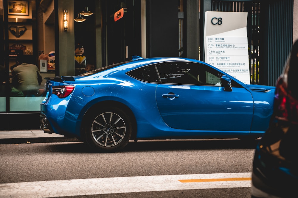 a blue car parked on the side of a street