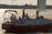 A joyful group of friends celebrating a birthday on a yacht at sunset with blue and turquoise decorations.