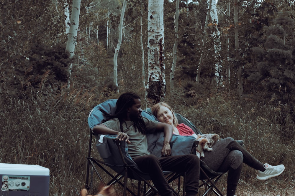 a group of people sitting in chairs outside with a dog