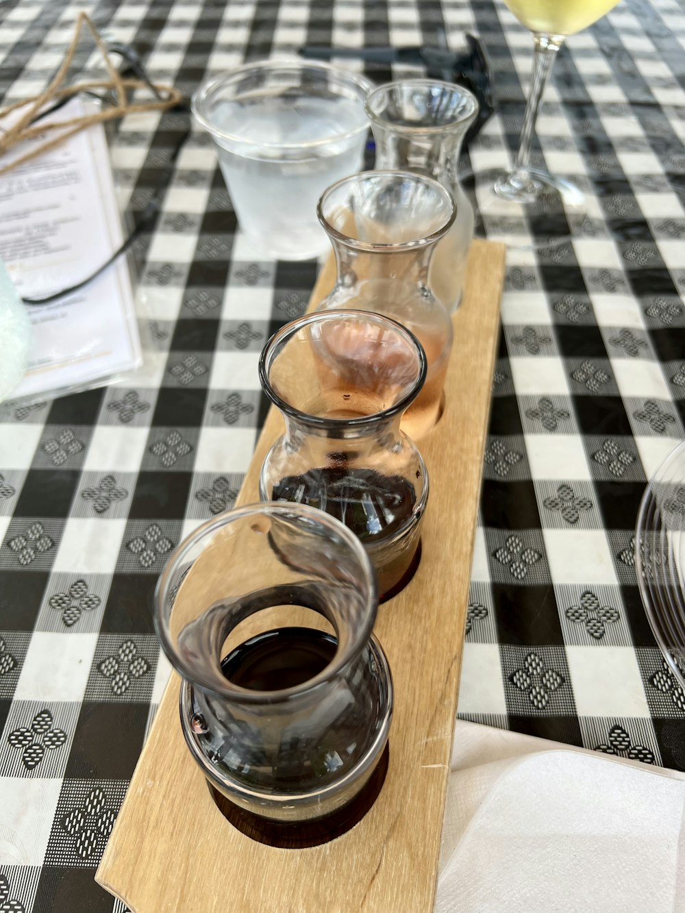 a glass bottle with a brown liquid in it next to a glass with a brown liquid in it