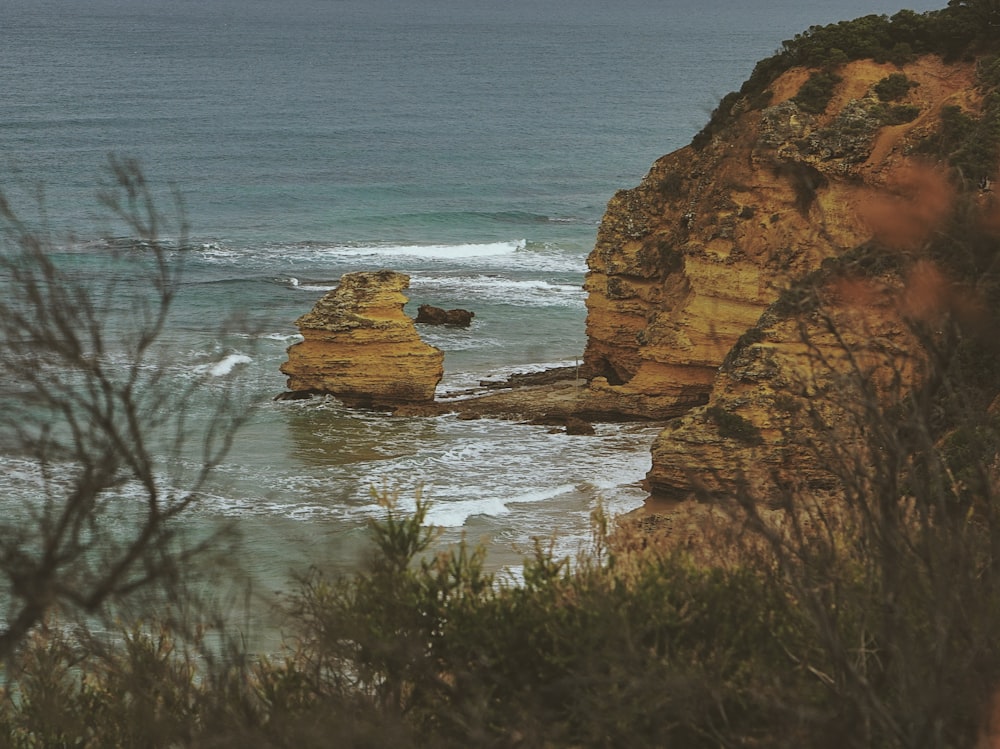 a rocky beach with a body of water in the background