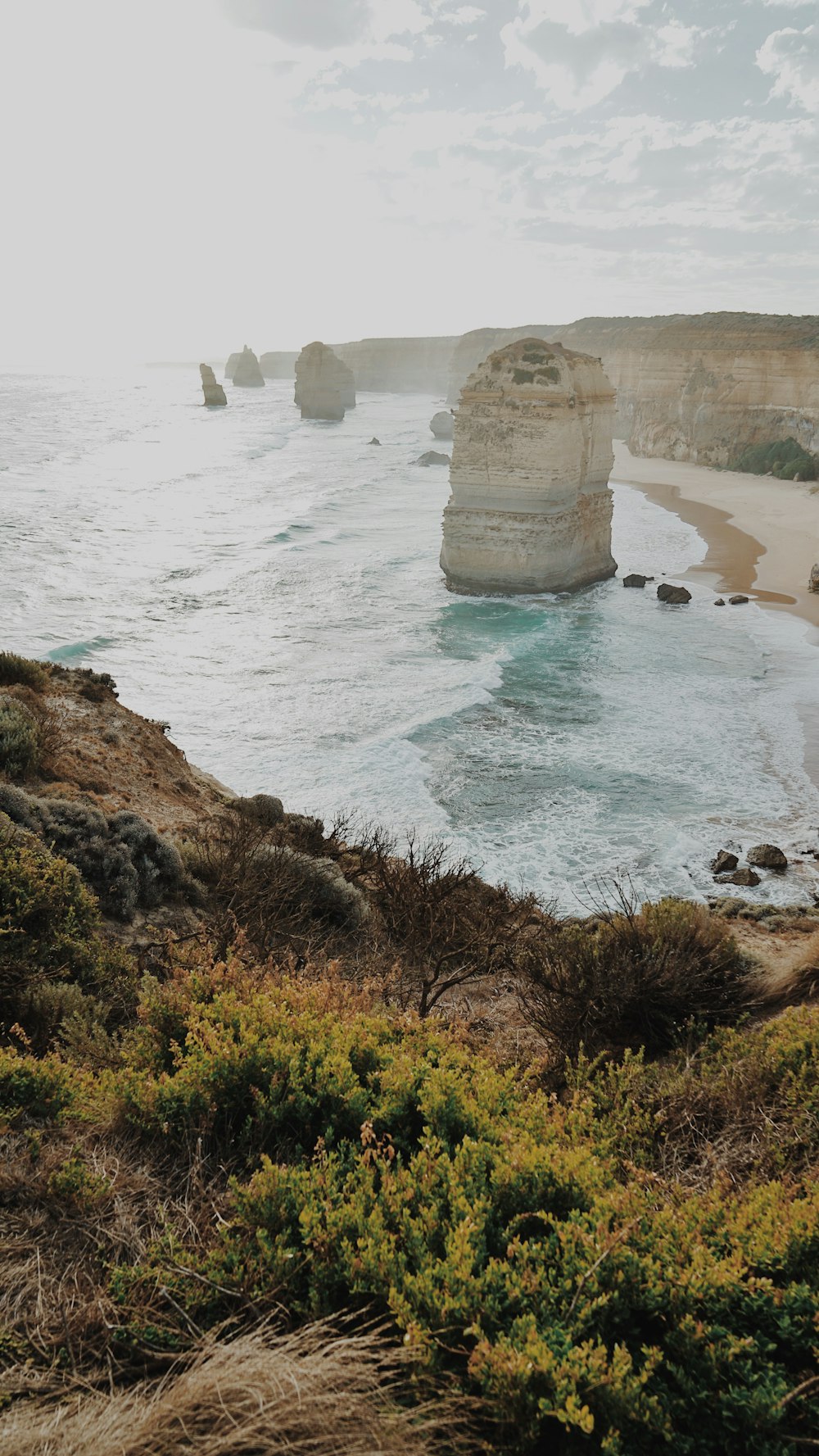 a rocky beach with a large rock formation in the middle