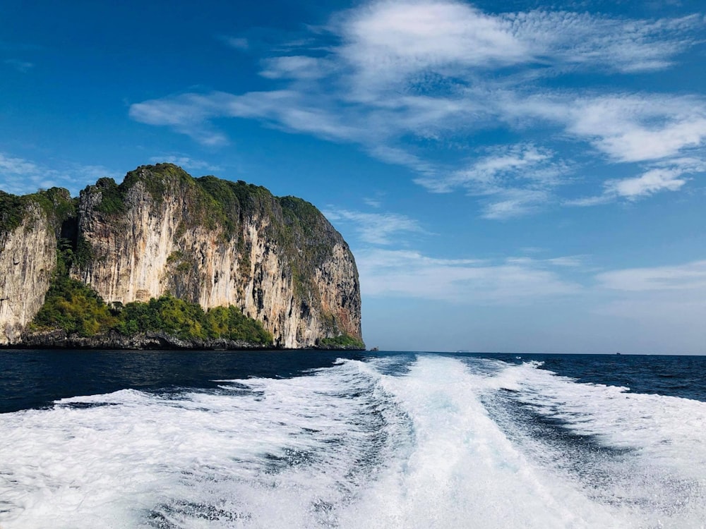 a body of water with a rocky cliff in the background