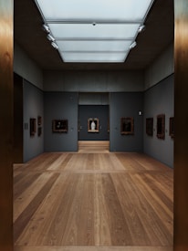 Elegant gallery space with deep black walls showcasing luminous paintings.