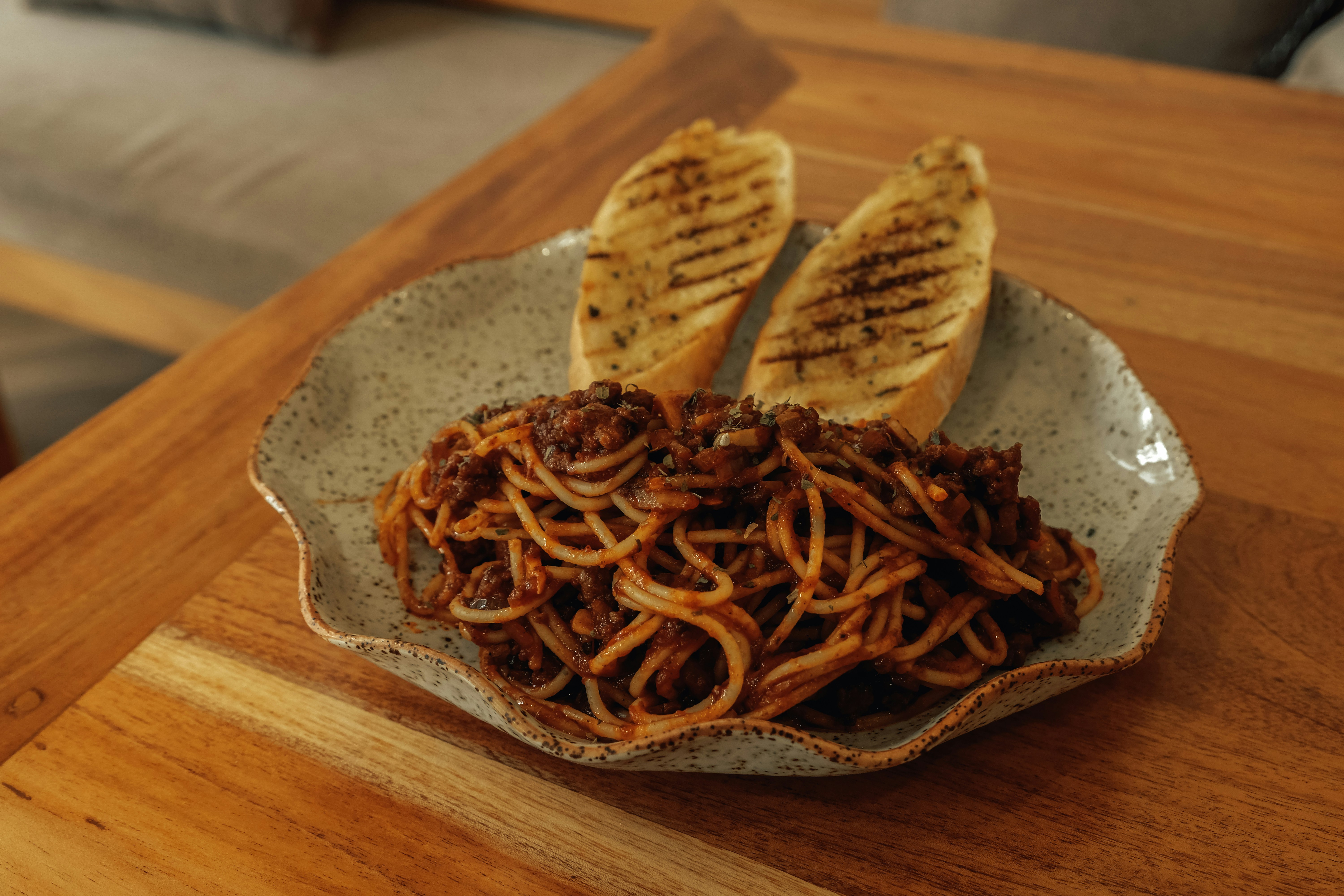 Spaghetti with garlic bread on a wooden table