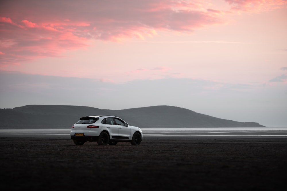 a white car parked on a beach